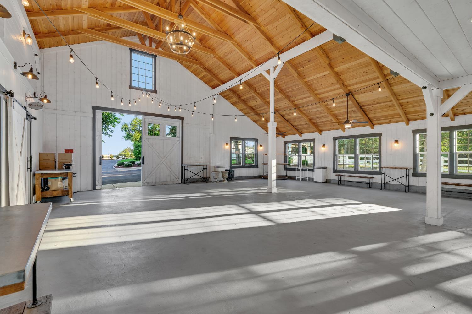 2905 Virginiatown Road Lincoln, CA 95648 - Photo 57 of 86 Event barn- Spacious interior featuring a vaulted wood-finish ceiling with exposed beams, white board-and-batten walls, and concrete flooring