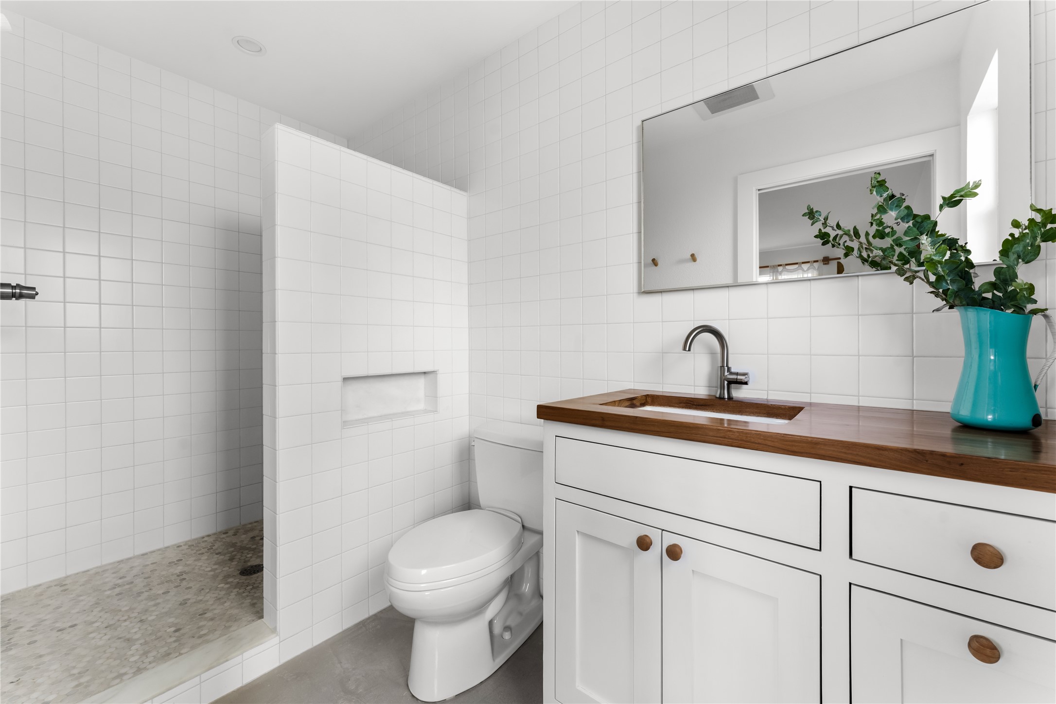 400 Delmar Avenue Austin, TX 78752 - Photo 25 of 36 The ensuite bathroom has been thoughtfully updated with a spacious walk-in shower and a walnut vanity that brings depth and warmth to the space