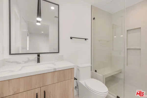 a bathroom with a sink toilet vanity and shower