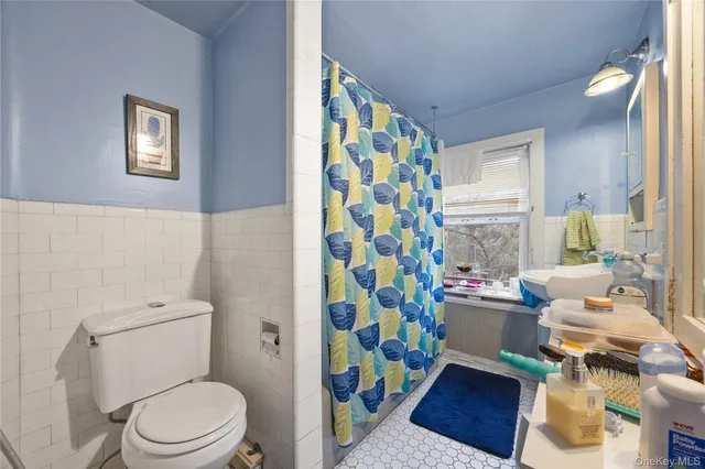 a white toilet sitting next to a shower curtain