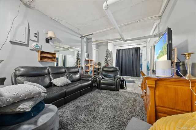 a living room with furniture a flat screen tv and a window