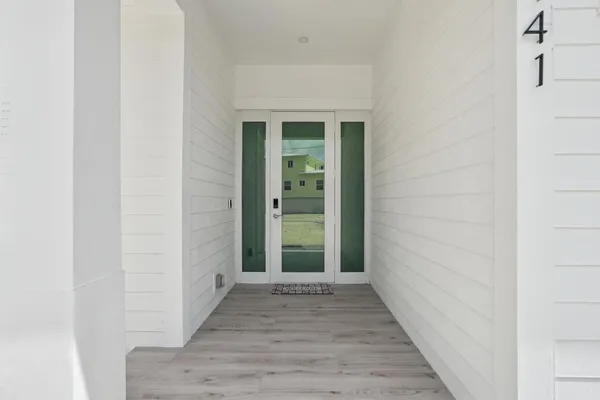 an empty room with wooden floor and a bathroom