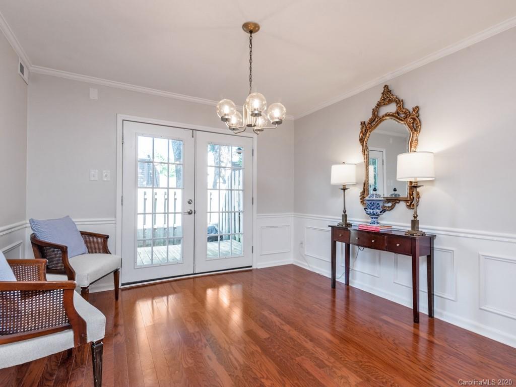 3516 Colony Road, Unit A Charlotte, NC 28211 - Photo 9 of 29 a dining room with wooden floor a chandelier a glass table and chairs
