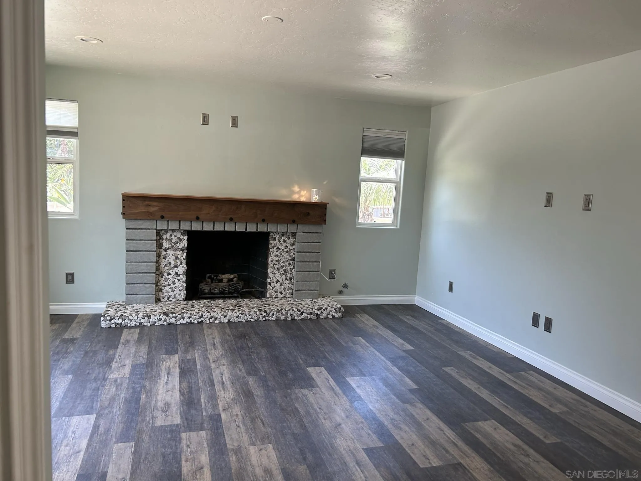 15408 Espola Road Poway, CA 92064 - Photo 14 of 27 a view of an empty room with wooden floor and a fireplace