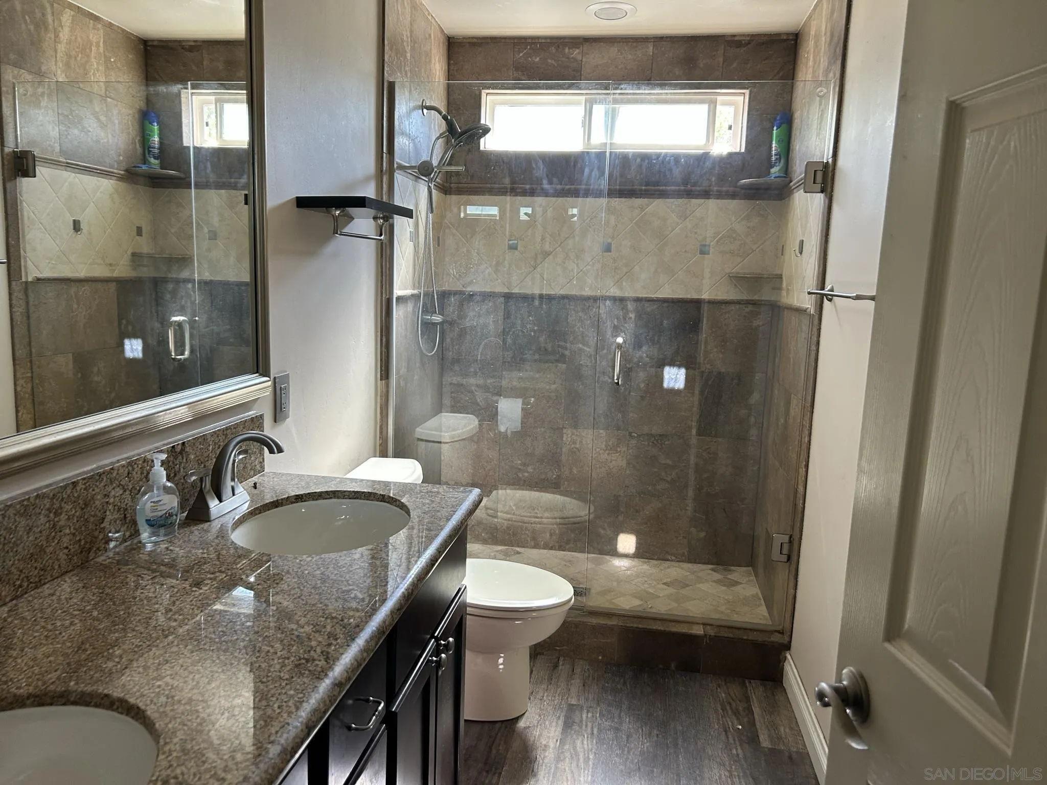 15408 Espola Road Poway, CA 92064 - Photo 19 of 27 a bathroom with a granite countertop shower a sink and a toilet