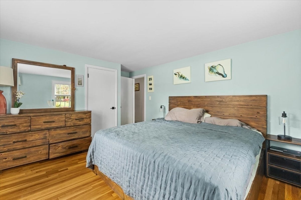 100 Whiting Street Hingham, MA 02043 - Photo 23 of 34 a bedroom with a bed and a mirror on dresser