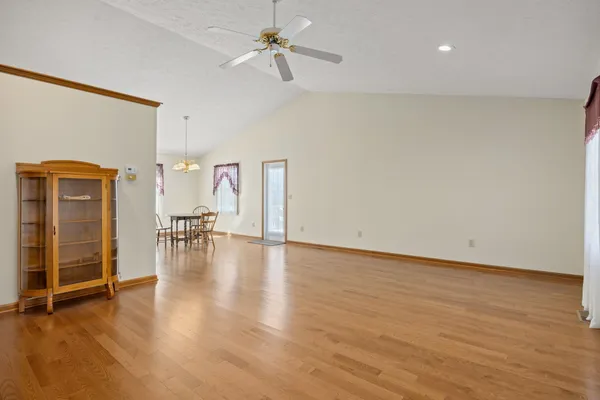 a view of empty room with wooden floor and windows