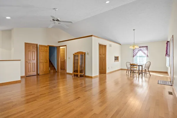 a view of empty room with wooden floor and fan