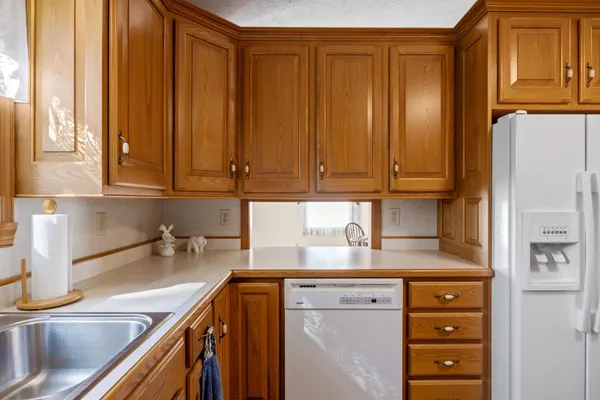 a kitchen with stainless steel appliances granite countertop a sink a refrigerator and cabinets