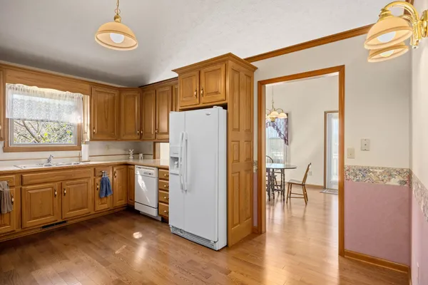 a kitchen with refrigerator a stove a sink and a window