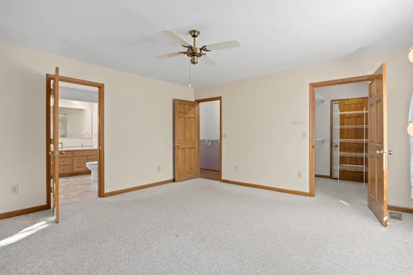 an empty room with closet and a chandelier fan
