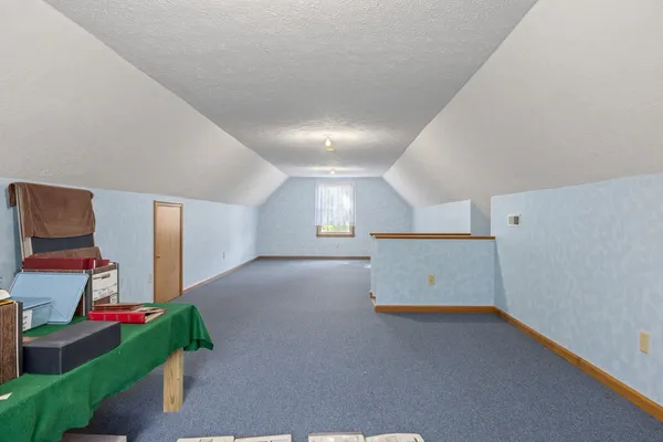 a view of an empty room with stairs and a window