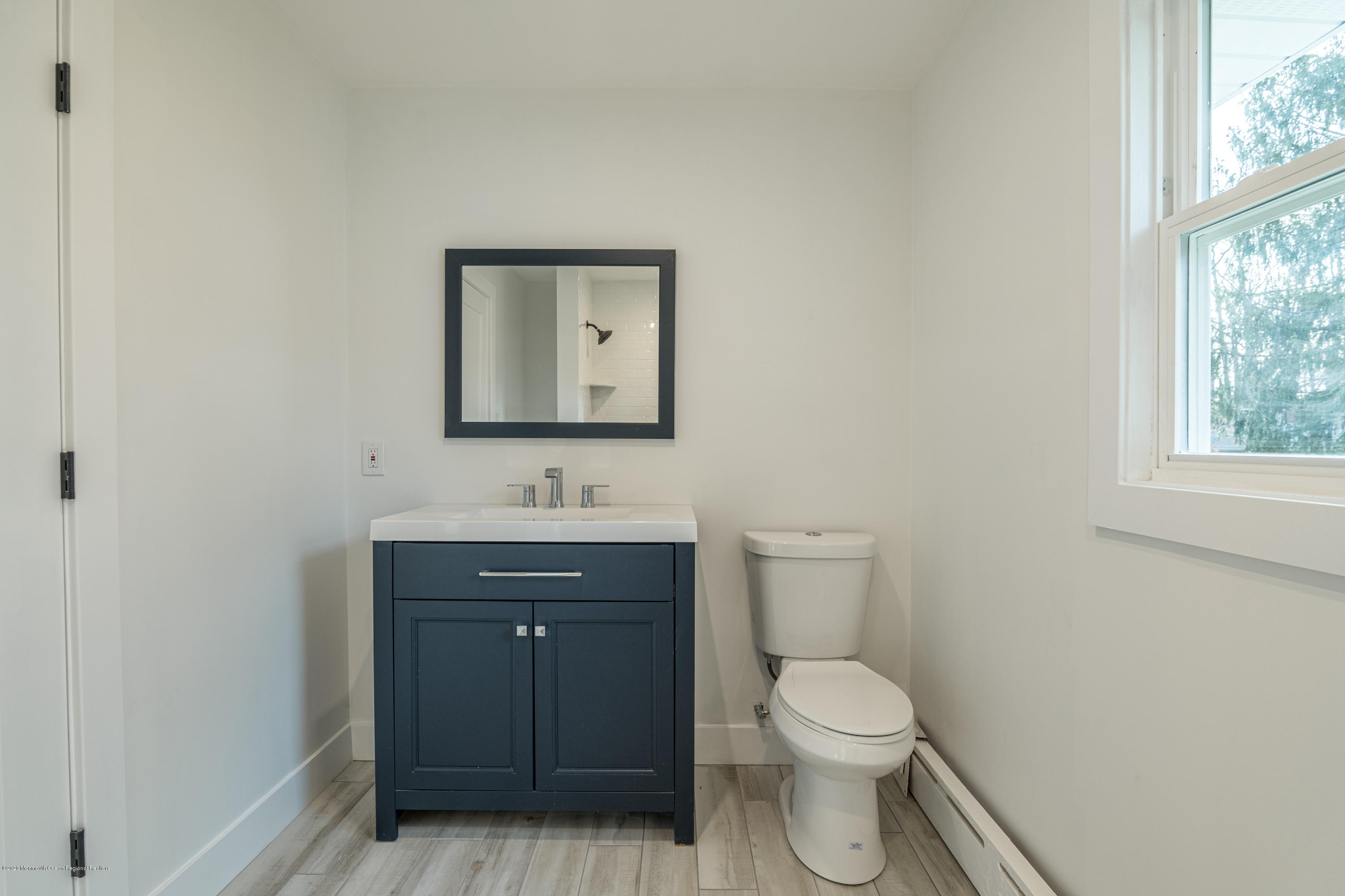 15 Johnson Road Lawrence Township, NJ 08648 - Photo 28 of 39 a bathroom with a toilet a sink a vanity and mirror