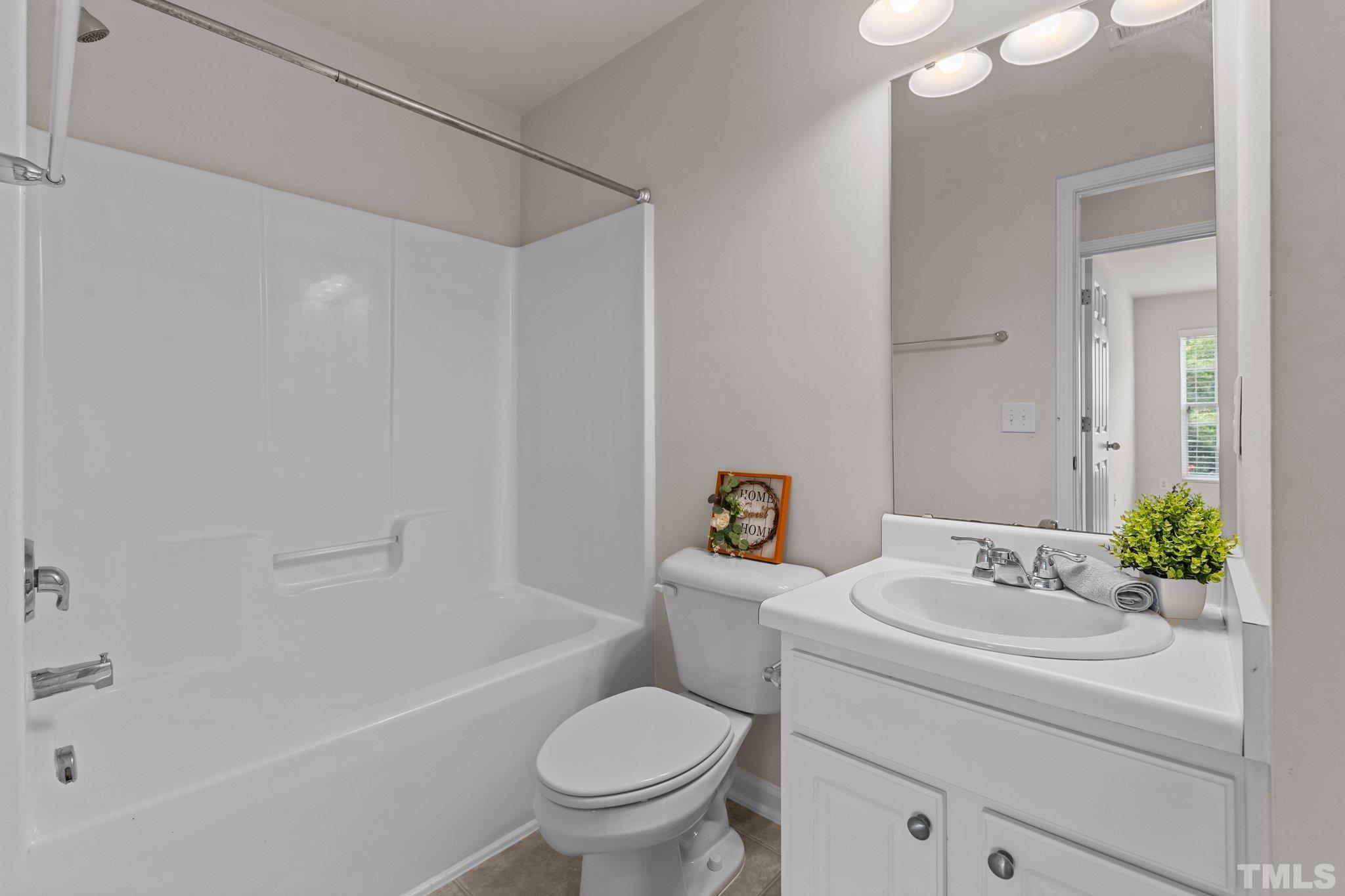 7154 Racine Way Raleigh, NC 27615 - Photo 21 of 31 a bathroom with a sink toilet and shower