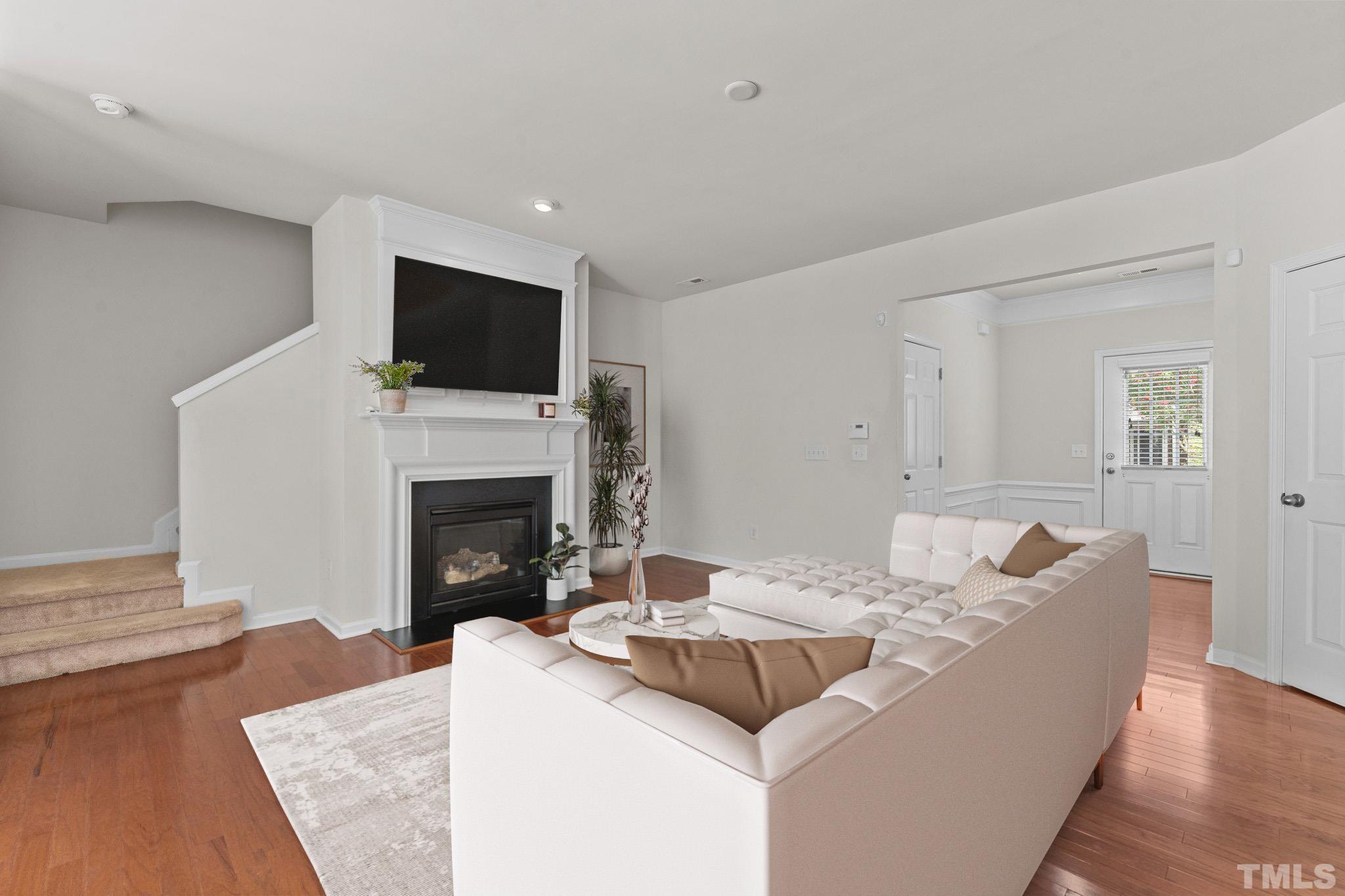 7154 Racine Way Raleigh, NC 27615 - Photo 5 of 31 a living room with furniture a fireplace and a flat screen tv