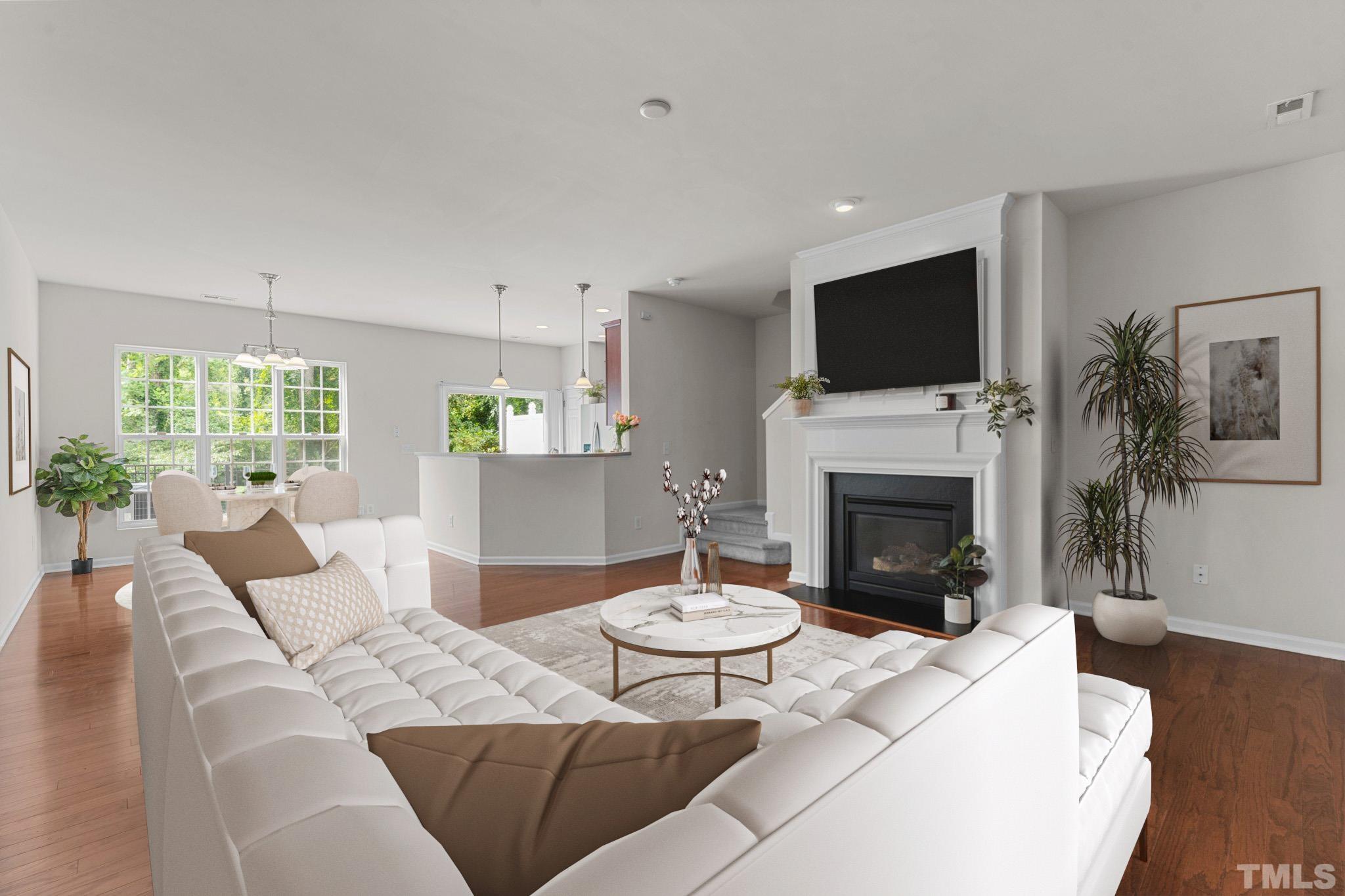 7154 Racine Way Raleigh, NC 27615 - Photo 7 of 31 a living room with furniture a fireplace and a flat screen tv