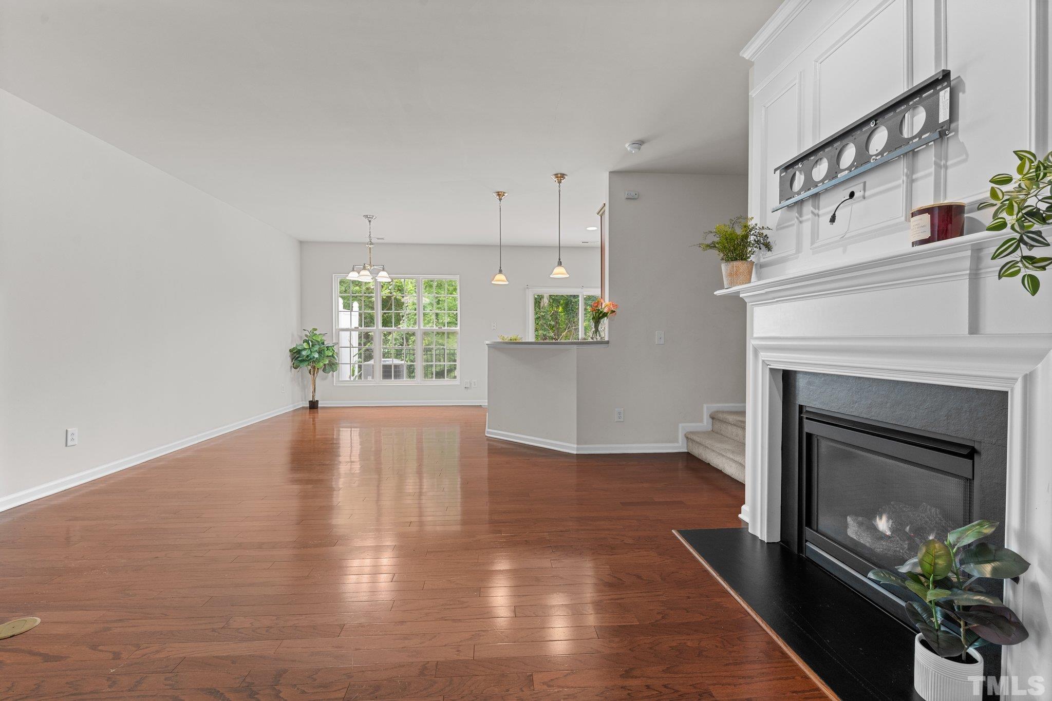 7154 Racine Way Raleigh, NC 27615 - Photo 9 of 31 a view of an empty room with a fireplace and wooden floor