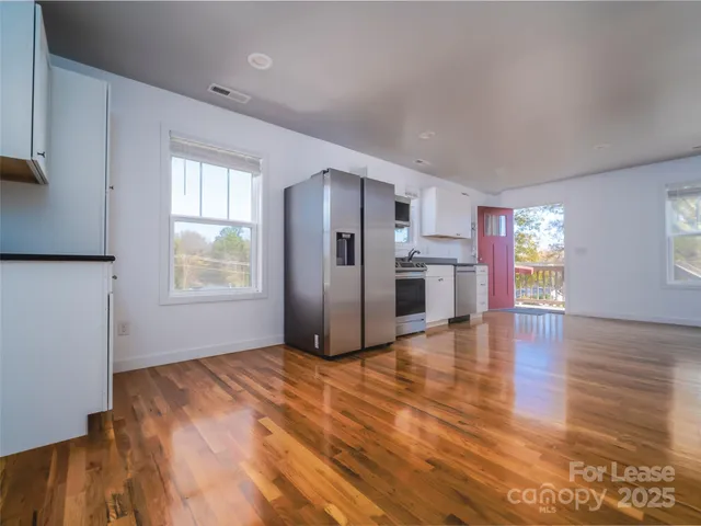 a view of a kitchen with wooden floor and a kitchen
