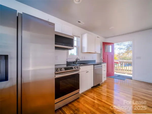 a kitchen with stainless steel appliances granite countertop a stove a sink and a refrigerator