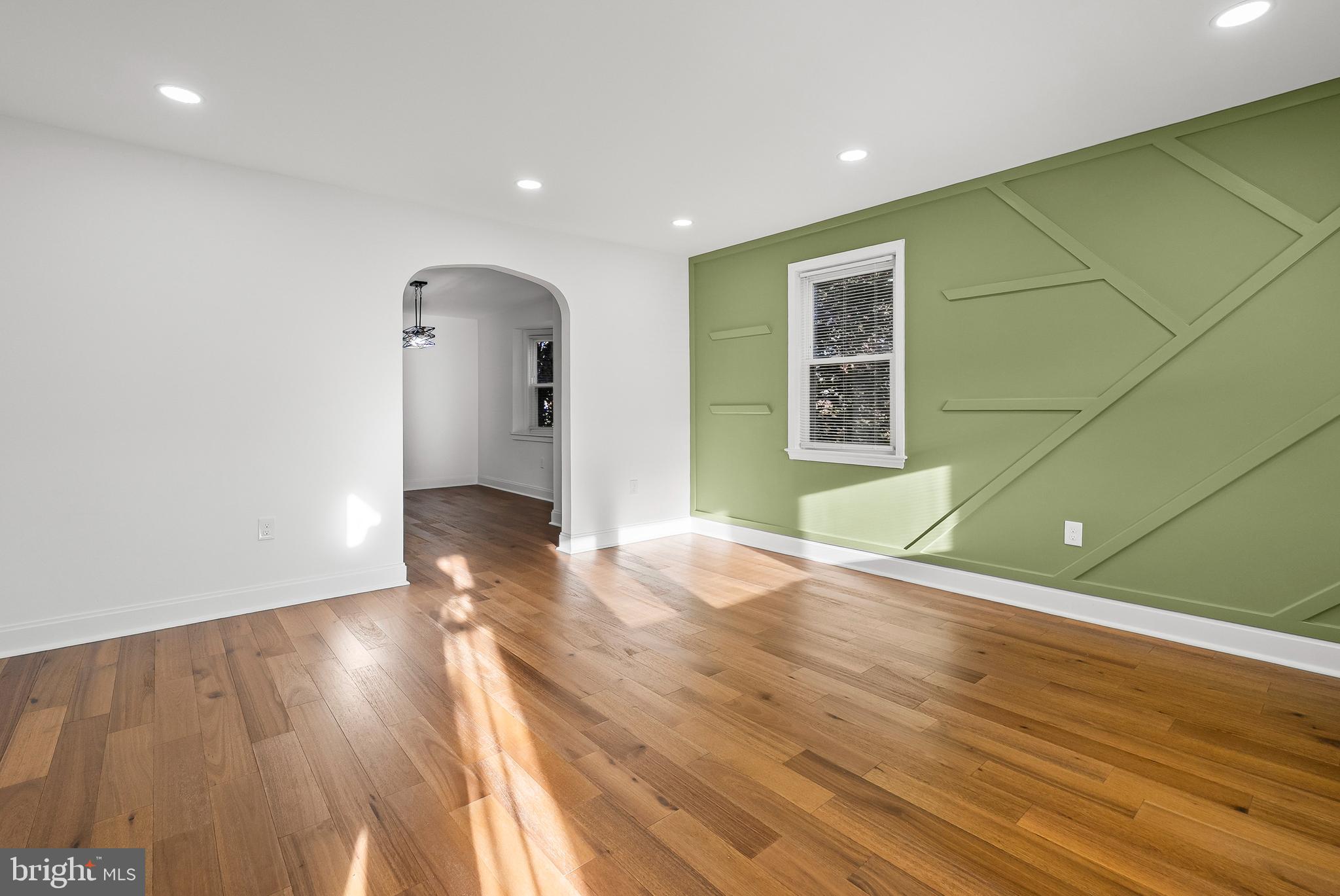5814 Falkirk Road Baltimore, MD 21239 - Photo 3 of 32 a view of an empty room with wooden floor and a window