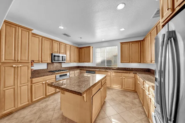 a kitchen with stainless steel appliances granite countertop a sink stove and cabinets