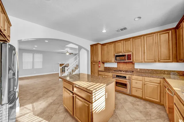 a kitchen with granite countertop a sink and a stove top oven