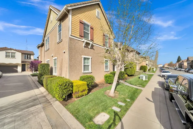 a view of an house with backyard and a tree