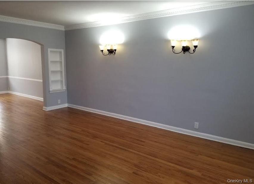 136-48 71st Road Queens, NY 11367 - Photo 2 of 13 an empty room with wooden floor and windows