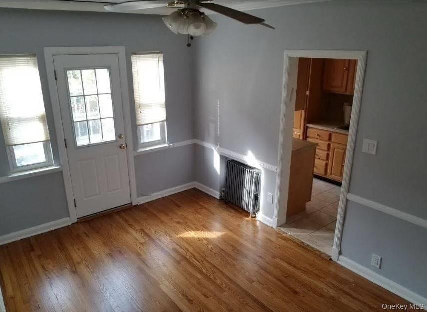 136-48 71st Road Queens, NY 11367 - Photo 3 of 13 an empty room with wooden floor and windows