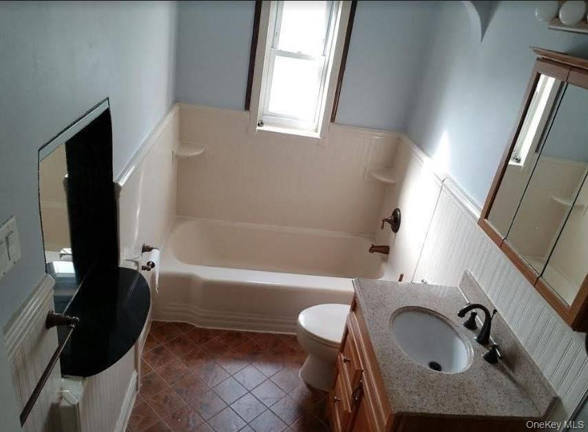 136-48 71st Road Queens, NY 11367 - Photo 5 of 13 a bathroom with a sink a bathtub and a toilet