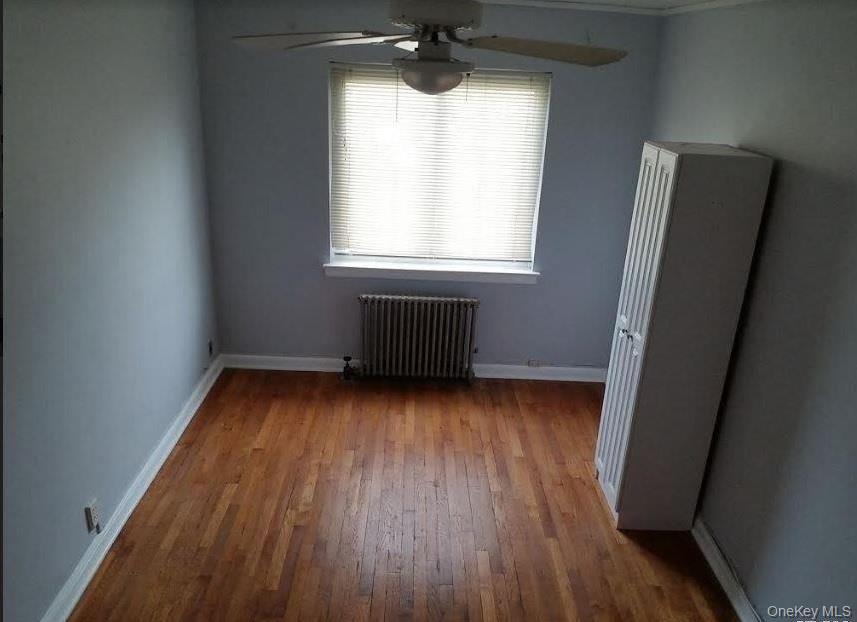 136-48 71st Road Queens, NY 11367 - Photo 6 of 13 a view of an empty room with wooden floor and a window
