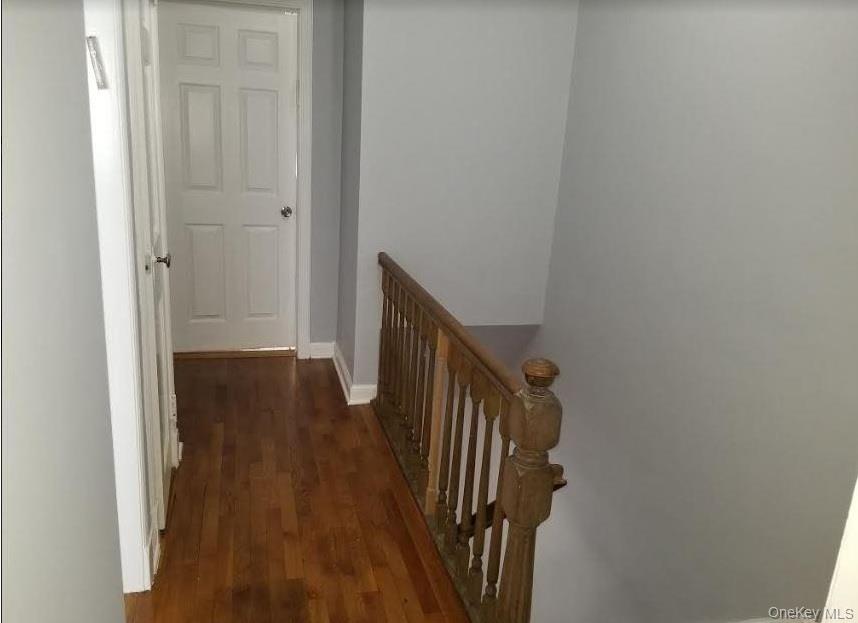 136-48 71st Road Queens, NY 11367 - Photo 8 of 13 a view of a hallway with wooden floor and staircase