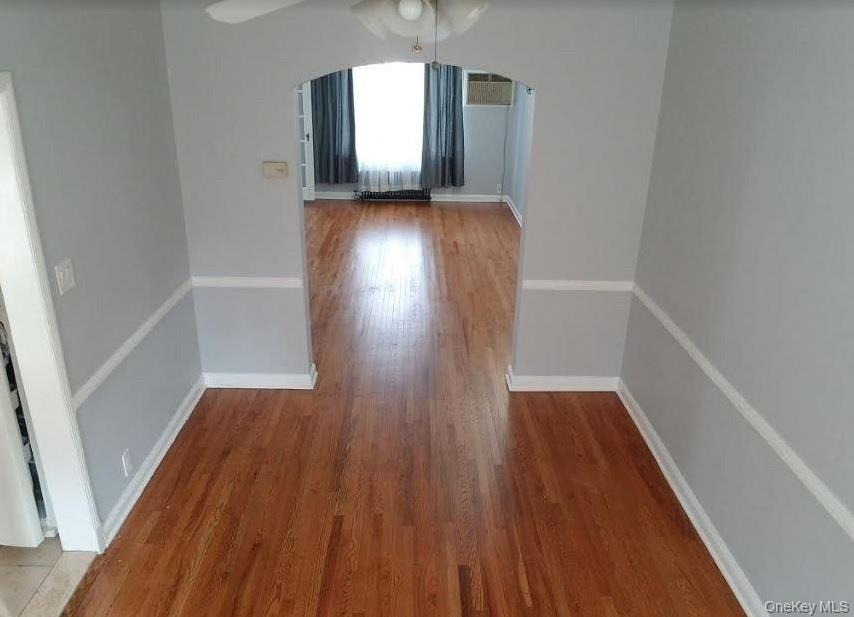 136-48 71st Road Queens, NY 11367 - Photo 9 of 13 wooden floor in an empty room with a window