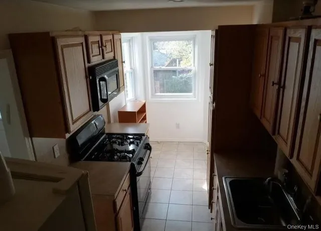 a kitchen with a black white stove top oven and sink