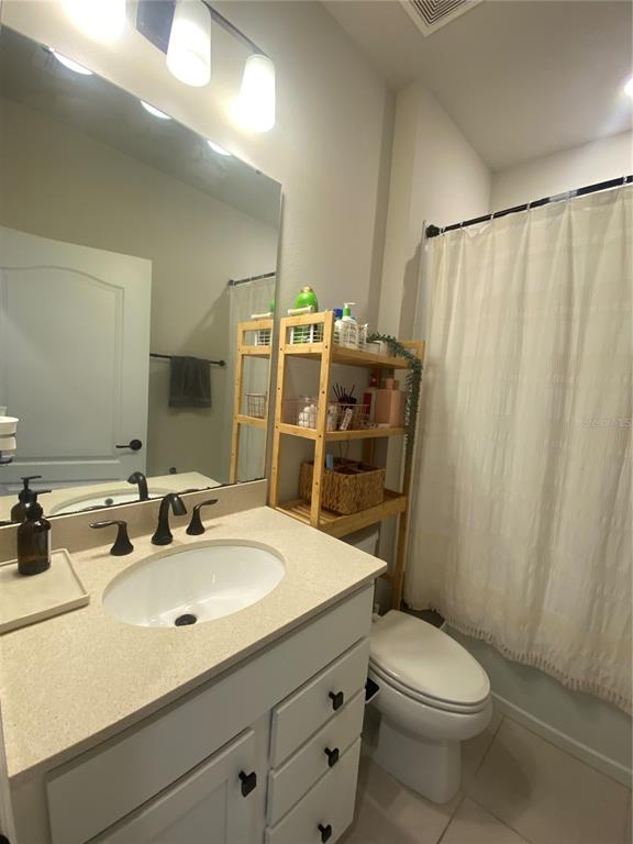 9610 Rally Spring Loop Wesley Chapel, FL 33545 - Photo 15 of 38 a bathroom with a sink a toilet a mirror and shower curtain