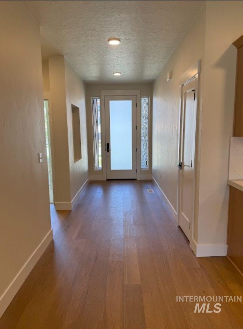 683 West Wrangler Street Meridian, ID 83646 - Photo 4 of 23 Entryway featuring wood-finish flooring, a frosted glass entry door, side lites with textured glass, recessed ceiling lighting, and a neutral color palette