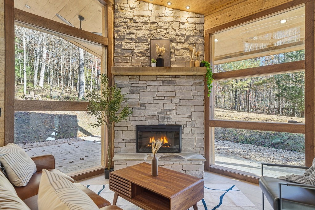 138 Cottonwood Lane Blue Ridge, GA 30513 - Photo 14 of 35 a living room with furniture a fireplace and a floor to ceiling window