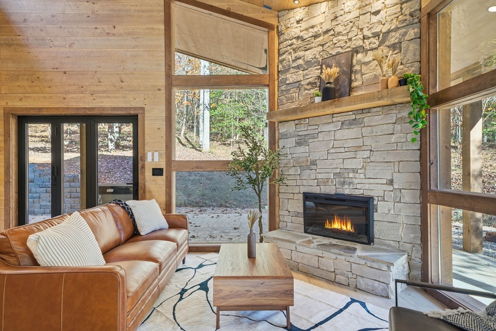 138 Cottonwood Lane Blue Ridge, GA 30513 - Photo 15 of 35 a living room with furniture a fireplace and a floor to ceiling window