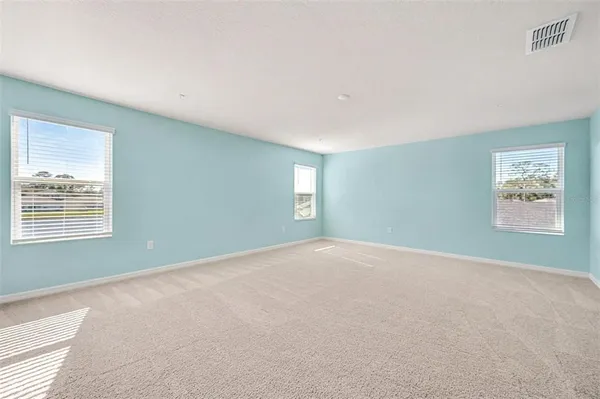 a view of a big room with windows and chandelier fan