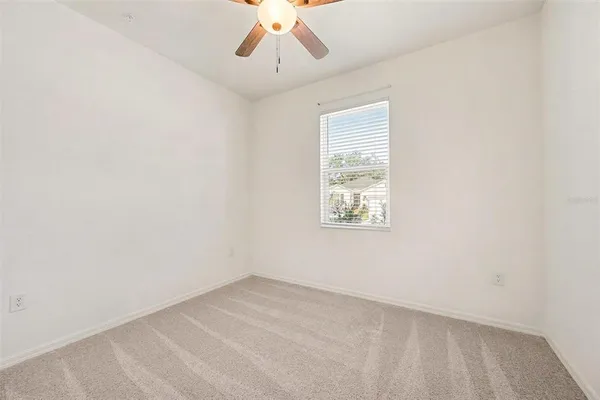 an empty room with a ceiling fan and a chandelier fan