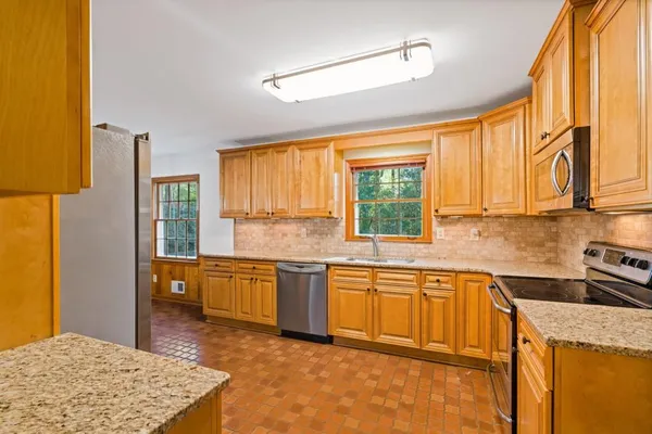 a kitchen with stainless steel appliances granite countertop sink stove and refrigerator