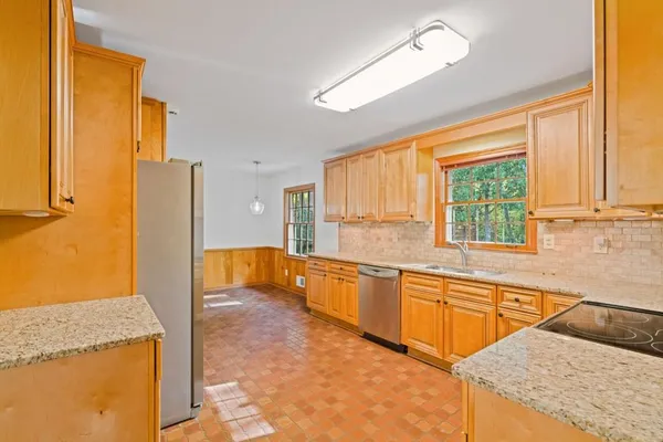 a kitchen with stainless steel appliances granite countertop a sink and a refrigerator
