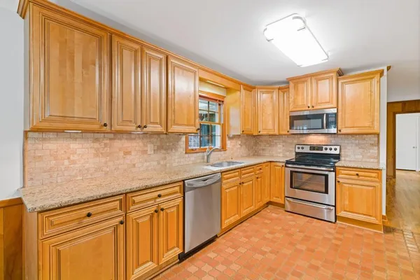 a kitchen with stainless steel appliances granite countertop a stove a sink dishwasher and a refrigerator