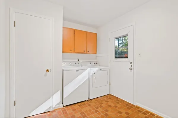 a view of an empty room with wooden floor and a fireplace