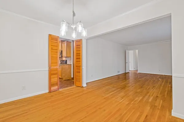 a view of empty room with wooden floor and window