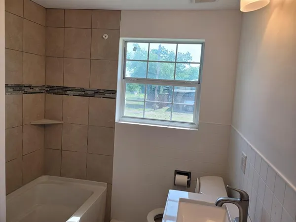 a bathroom with a window a bathtub and shower