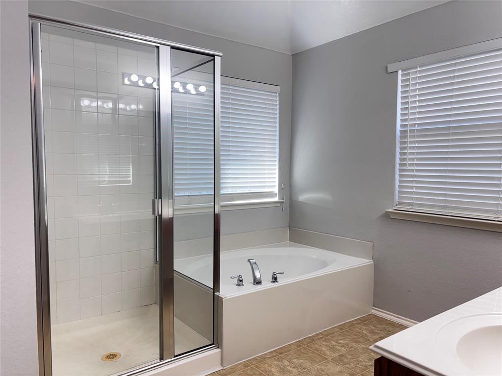 9704 Mystic Dunes Drive McKinney, TX 75072 - Photo 12 of 17 a bathroom with a bathtub and a shower