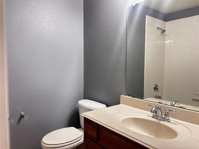 a bathroom with a sink a toilet a mirror and shower