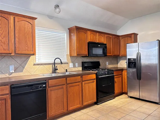 a kitchen with stainless steel appliances granite countertop a stove sink and refrigerator