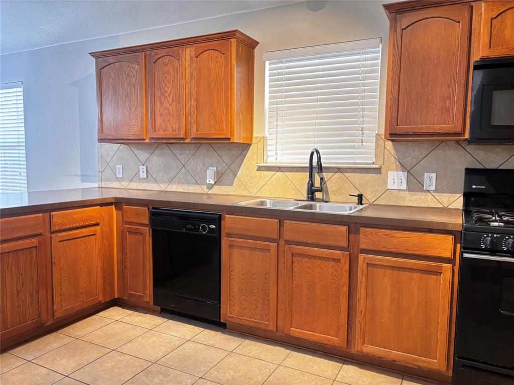 9704 Mystic Dunes Drive McKinney, TX 75072 - Photo 9 of 17 a kitchen with stainless steel appliances granite countertop a refrigerator and sink